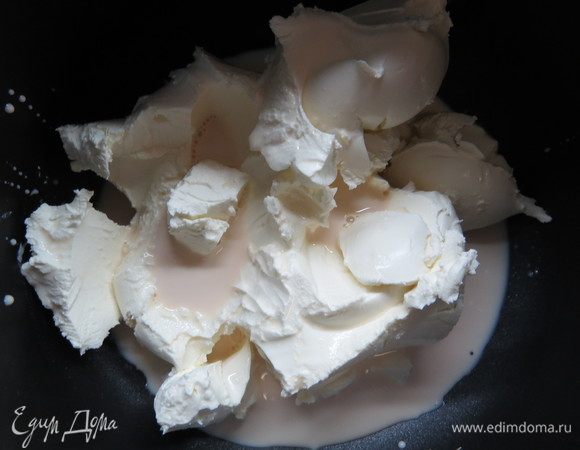 Прежде  всего, необходимо сделать топленый творожный сыр для чизкейка. Для этого в глиняный горшочек помещаем творожный сыр и топленое молоко, перемешиваем массу до однородности. Томим под крышкой в духовке около 8 часов при температуре 85–90°С, периодически помешивая творожную массу.
Также для этих целей можно воспользоваться мультиваркой, что я и сделала. 