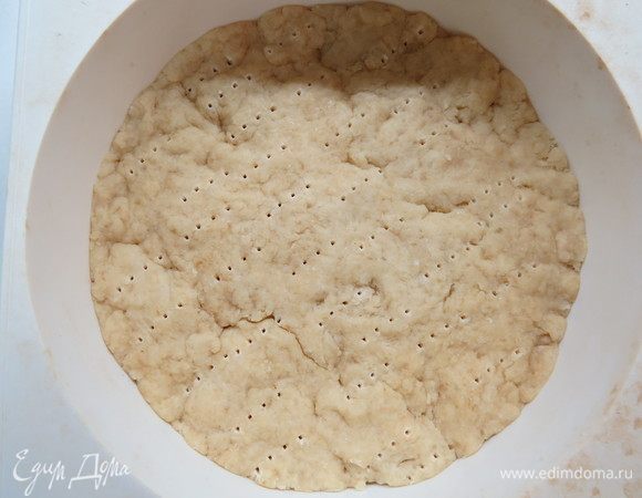 Вынимаем из холодильника творожное тесто, кладем его на дно формы (у меня силиконовая диаметром 18 см). Обычную разъемную форму нужно будет выстелить бумагой для выпечки. Наколоть тесто вилкой. Я люблю делать без бортиков, но можно и с ними.