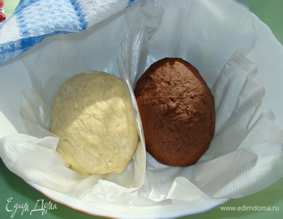 Тесто разделить на две равные части. В одну часть добавить какао-порошок и тщательно замесить. Обе части накрыть полотенцем и поставить в теплое место для подъема. 