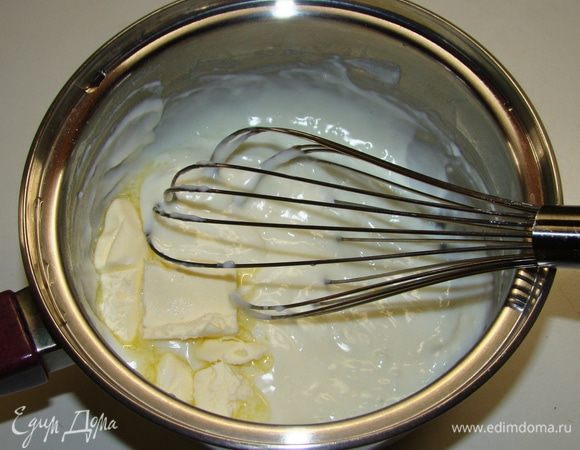 Загустевшее молоко снять с огня, добавить сливочное масло, перемешать до полного растворения масла и оставить на столе, чтобы остыло до комнатной температуры. 