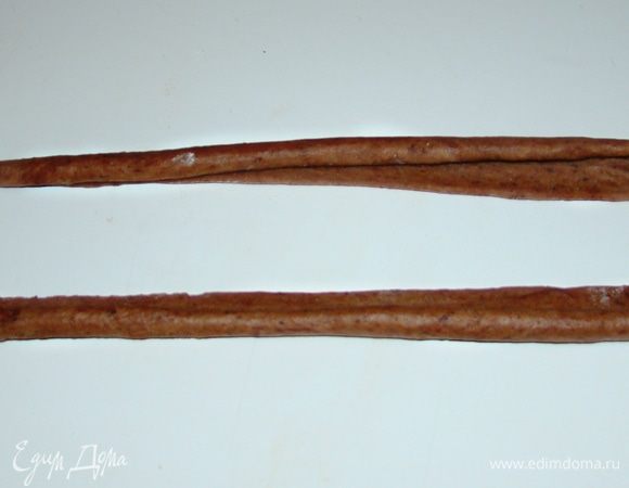 Из светло-коричневых кусочков теста раскатать длинные полоски (длина должна быть равна длине формы, в которой будет выпекаться хлеб) и свернуть каждую по всей длине в рулетик. 