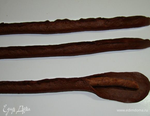 Из кусочков темного теста раскатать полоски такой же длины, как и форма для выпекания, а шириной, чтобы хватило обернуть трубочки из светло-коричневого теста. Каждую полоску светлого теста обернуть темным и защипнуть по всей длине. Аналогично проделать с белым тестом. 
