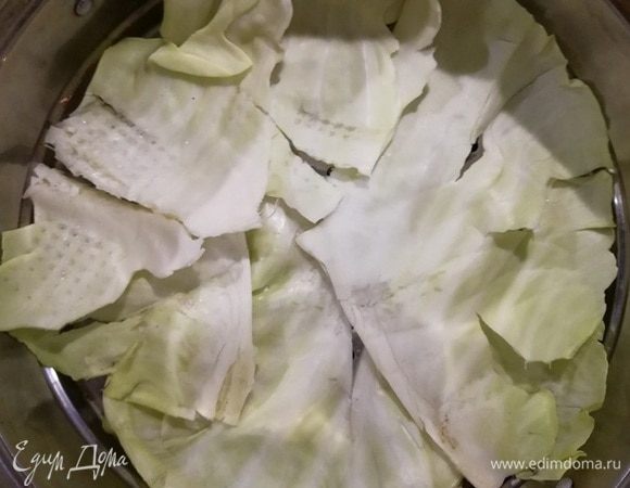 На дно формы для мантоварки я положила капустные листья, чтобы тесто не прилипало ко дну. Можно из пергаментной бумаги вырезать круг по диаметру формы и обильно смазать его маслом. 