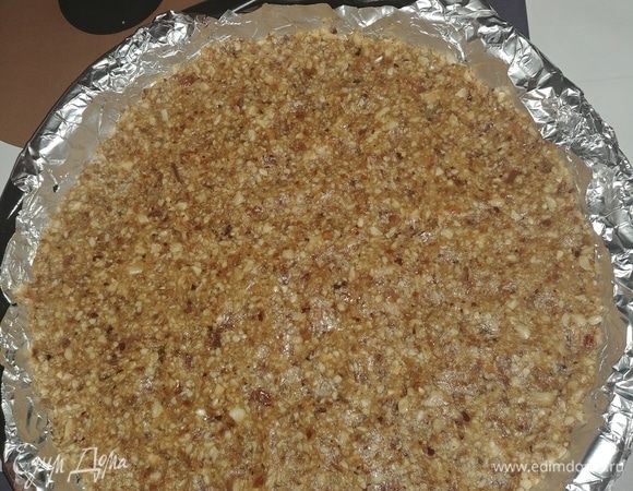 Форму выстилаем фольгой или бумагой для выпечки. Получившуюся ореховую смесь выкладываем в форму, хорошо выравниваем и немного придавливаем. 