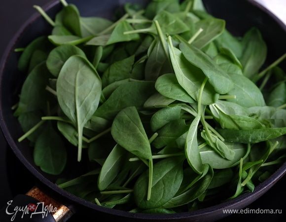 Духовку разогреть до 180°С. На сковороде разогреть 1 ст. л. масла и выложить свежий шпинат.