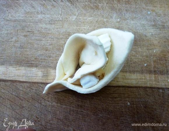 Накрываем начинку другой стороной квадратика и скрепляем концы сгиба. Получаются что-то наподобие ушек с устойчивой стороной.