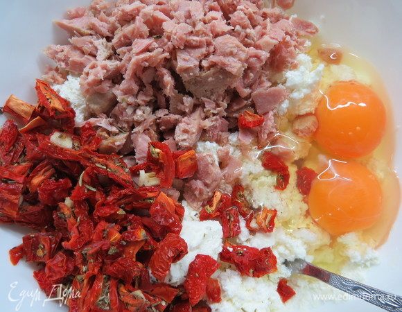 В творог добавить яйца, тунца, вяленые помидоры, перемешать.