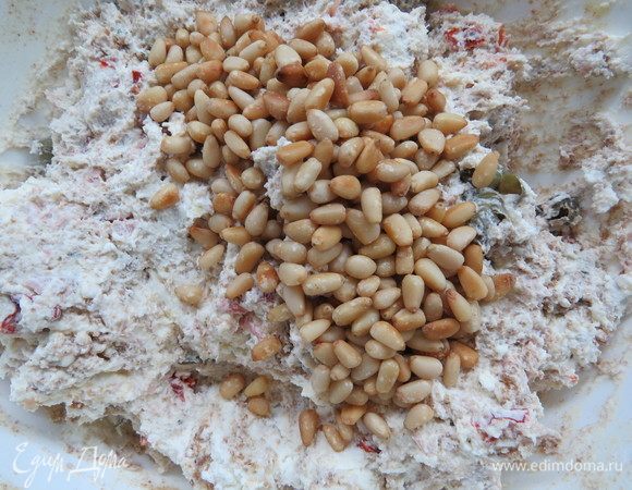 В конце всыпать половину кедровых орехов, перемешать.