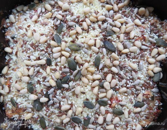 Форму диаметром 20 см смазать маслом. Выложить творожную массу в форму, разровнять и посыпать сверху оставшимися орешками и смесью семян (у меня подсолнечник, семена тыквы и льна). Поставить форму в разогретую до 170°С духовку и выпекать примерно 50 минут. Через 25–30 минут после начала запекания орешки сверху подрумянятся, чтобы они не сгорели форму следует накрыть кусочком фольги.