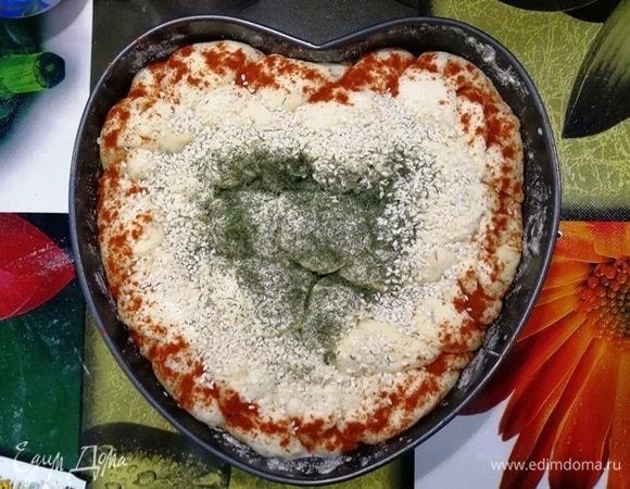 Тесто смажьте молоком комнатной температуры. По краям я посыпала хлеб паприкой, в центре сушеный укроп, оставшееся пространство я украсила кунжутом. 