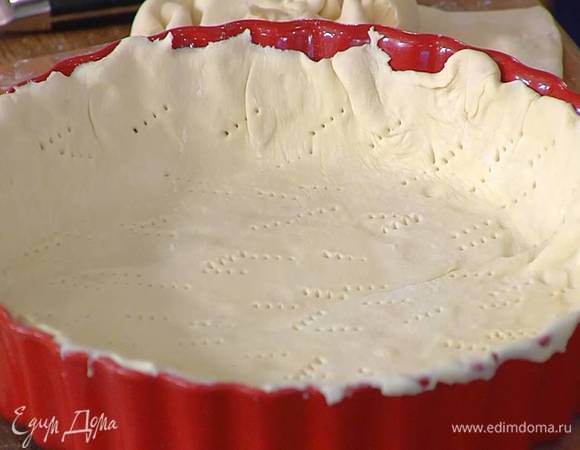 Один пласт теста раскатать, выложить в форму, так чтобы получились бортики, и часто наколоть вилкой, затем накрыть бумагой для выпечки и насыпать сверху сухой горох или фасоль.