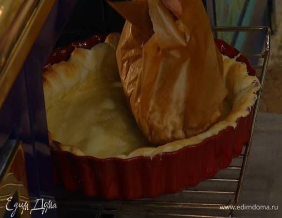 Выпекать тесто в разогретой духовке 15 минут, затем понизить температуру в духовке до 180°С, снять бумагу с горохом и дать середине теста слегка подпечься.