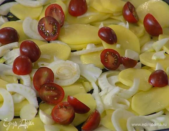 Помидоры разрезать пополам и разложить сверху на овощи.