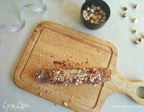Сверху так же смазываем нутеллой и посыпаем дробленым фундуком. Теперь порежем с помощью острого ножа.