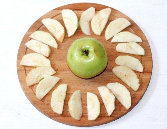 Приготовим яблоки. Удаляем из яблок (из 1,5 шт.) семечки и очищаем от шкурки. Нарезаем яблоки дольками. Половину неочищенного яблока оставляем для украшения серединки.