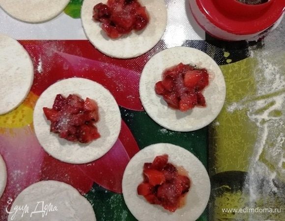 В центр заготовки положите чайную ложку клубники и 1/2 чайной ложки сахара.