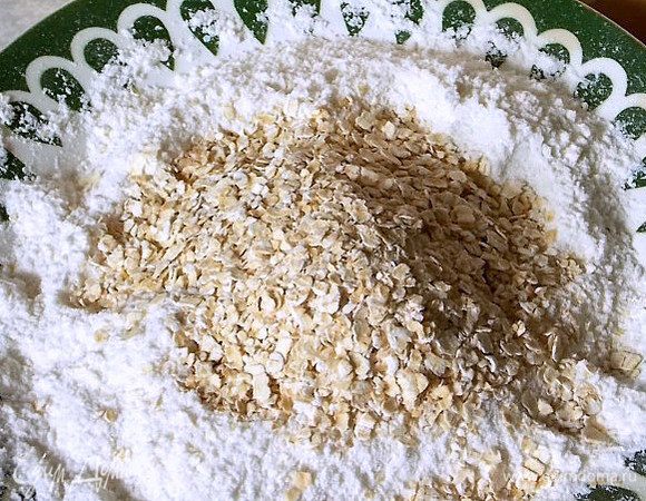 Смешать в чаше овсяные хлопья, муку, сахар, кокосовую стружку, корицу и разрыхлитель.