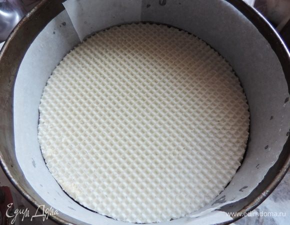 Разъемную форму выбирайте такого размера, чтоб туда плотно входил вафельный корж. В моем случае это форма 22,5 см. Дно и бока формы выстилаем пергаментом, кладем вафлю.