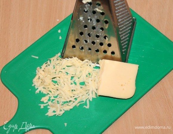 Приготовим начинку. Сыр натереть на крупной терке и выложить в миску.
