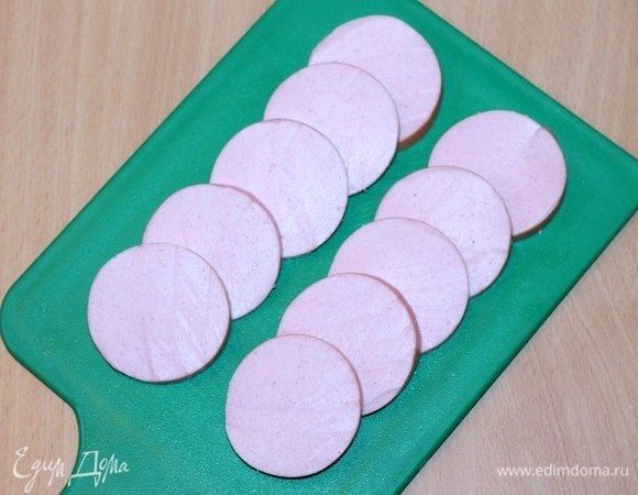 Вареную колбасу нарезать кружочками (12 шт). Кружок колбасы у меня Ф=6 см и толщиной от 0,6–1 см.
