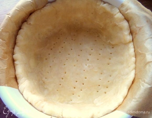 Застелить керамические порционные формочки (диаметр 11 см) полоской пергамента, чтобы легче было потом достать, смазать кисточкой с маслом и распределить тесто по дну и бортикам.