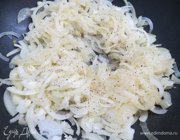 Готовим начинку. Репчатый лук почистить и нарезать тонкими полукольцами либо четверть кольцами. Выложить лук на сковороду с разогретым растительным маслом и обжарить до мягкого состояния и светло-золотистого цвета. Обжаренный лук посолить, поперчить.