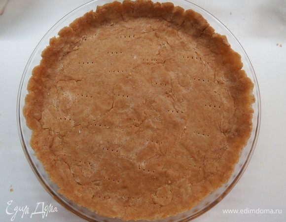 Тесто достать из холодильника и тонко раскатать в форме диаметром 26–27 см, сделать бортики.