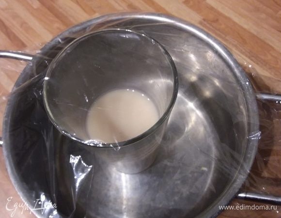 Накануне вечером растворить в теплой воде соль. Затем раскрошить в воду дрожжи и деревянной ложечкой размешать, пока дрожжи полностью разойдутся. Накрыть стакан пленкой и поместить в холодильник на ночь. Я не была уверена, как поведет себя опара, поэтому поставила на всякий случай стакан в кастрюльку. Наутро оказалось, что предосторожность была лишней. 