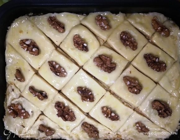 Смажьте тесто яйцом, выложите грецкие орехи и отправьте тесто в разогретую до 200°С духовку на 15 минут.