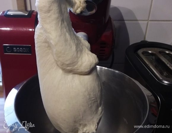 На следующий день просеять муку, смешать ее с дрожжевой смесью, медом и 200 мл теплой воды. Я замешивала тесто в комбайне, первые 5 минут на малых оборотах, затем увеличила скорость и замешивала еще 10 минут, постепенно добавляя кусочками размягченное сливочное масло. Тесто мягкое, эластичное, гладкое, абсолютно не липнет к рукам, стенки чаши комбайна чистые, без остатков теста. Накрыть чашу пленкой и поместить в нагретую до 30°С духовку на 90 минут. 