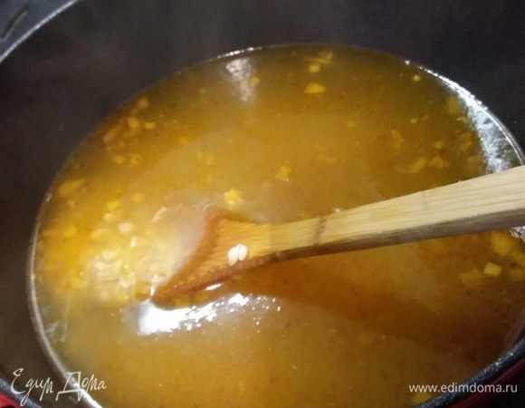 Пока варится бульон, разогреть в другой кастрюле масло и спассеровать лук, добавить томат, обжарить и влить бульон. Засыпать промытую перловку и варить до готовности. 