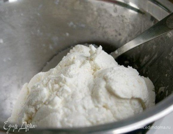 В творог добавить щепотку соли, сахар (много класть не стоит, иначе сырники от сиропа раскиснут, потребуют больше муки, в результате, будут жесткими и невкусными и подгорят) и 1 ст. л. муки. Хорошенько размешать. Творог не должен липнуть к рукам.