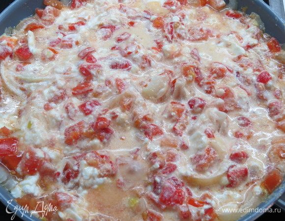 Выложить в сковороду с луком и помидорами натертую брынзу и нарезанный печеный перец, перемешать.