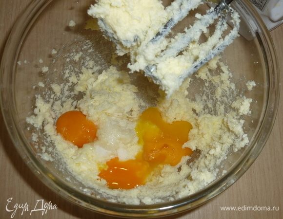 Масло заранее достать из холодильника, чтобы оно стало комнатной температуры. 
Взбить миксером масло с сахаром в пышную массу. Добавить желтки, ванильный экстракт и перемешать.