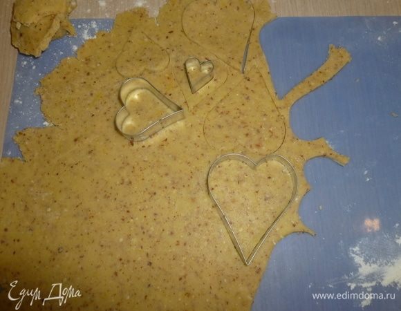 Противни застелить пергаментом. Раскатать тесто. С помощью формочки вырезать из теста сердечки (звездочки и т.д.). Затем вырезать сердечки меньшего размера, в которых вырезать еще окошко.