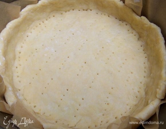 Тесто размять по форме диаметром 21 см на смазанном пергаменте. Дно наколоть вилкой.