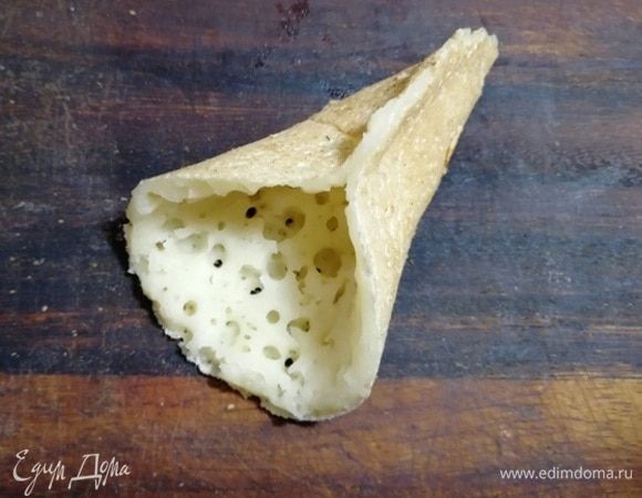 Пока блинчик еще теплый, соединяем края до середины. Получается кулечек. Можно начинять его.