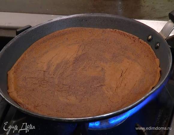 Разогреть блинную сковороду, с помощью кисточки смазать ее оливковым маслом, напечь шоколадных блинов и остудить их.