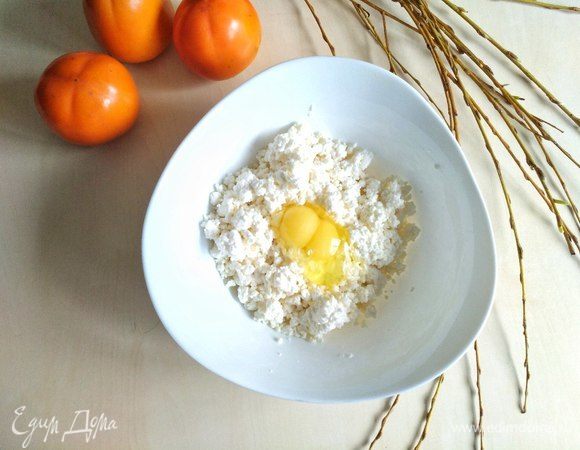 Кладем творог в большую миску, вбиваем туда 2 яйца.