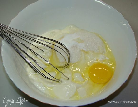 Пока творожный слой запекается, приготовим заливку. Для этого сметану смешаем с яйцами, сахаром и щепоткой ванилина. 
