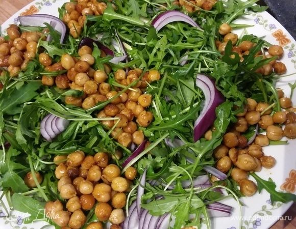 Лук нарезать полукольцами или лепестками. Разложить руколу, лук, авокадо будем резать в самом конце. Выложить слегка теплый нут. 