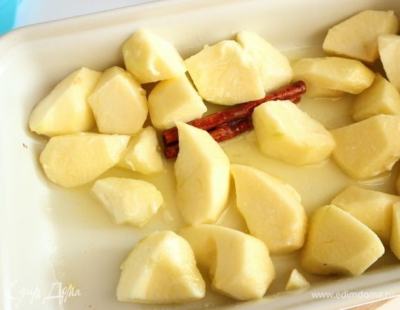 Духовку разогреть до 200°С. Яблоки «Голден» почистить, удалить семенную часть, нарезать произвольно на кусочки. Поместить в форму яблоки, масло, сахар, палочку корицы, лимонный сок. Поставить форму в духовку. 