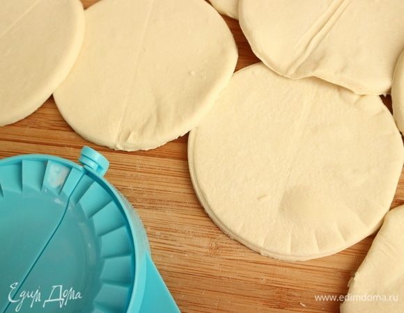 Вырезать кружочки из теста. На фотографии — кружочки из толстого слоя теста, которое предварительно не раскатывала. Формочка для шоссонов — очень удобно. Можно вырезать чашкой, верхняя часть которой диаметром 9 см. Край в этом случае можно пройти колесиком для пиццы, тогда он будет волнистым.