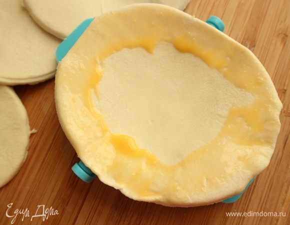 Положить в формочку тесто, обмазать края смесью 1 желтка и 1 ч. л. воды.