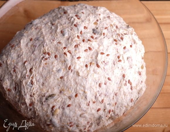 Через 20 минут добавить в чашу соль и начать вымешивать тесто на 2-ой скорости миксера до эластичного гладкого состояния. Обычно на это уходит 15–20 минут. За 10 минут до конца замеса внести семена и вмешать их в тесто. Готовое тесто подкрутить в плотный шар, положить в миску, смазанную растительным маслом, накрыть пленкой и поставить на брожение на 3,5–4 часа.