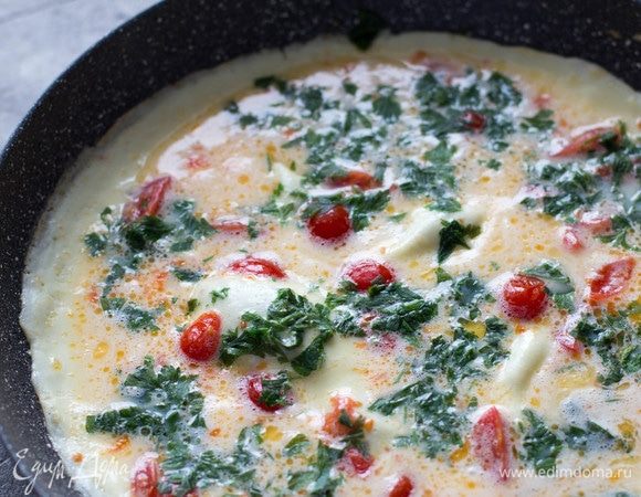 Добавить зелень, накрыть крышкой и оставить на плите на 3–4 минуты. Когда омлет уже почти затвердел, убавить огонь на минимум и добавить натертый сыр. Дать постоять 15 секунд. Затем снять блюдо с огня и свернуть конвертиком (завернуть края омлета вовнутрь с трех сторон).