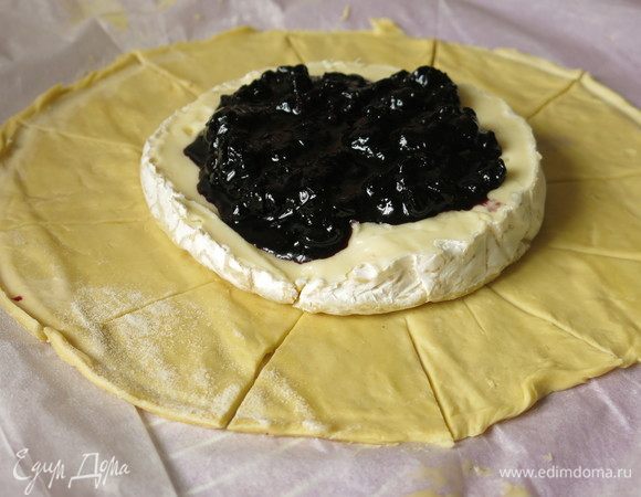 Выкладываем тесто, вырезаем круг, кладем в центр сыр и на него чернику.