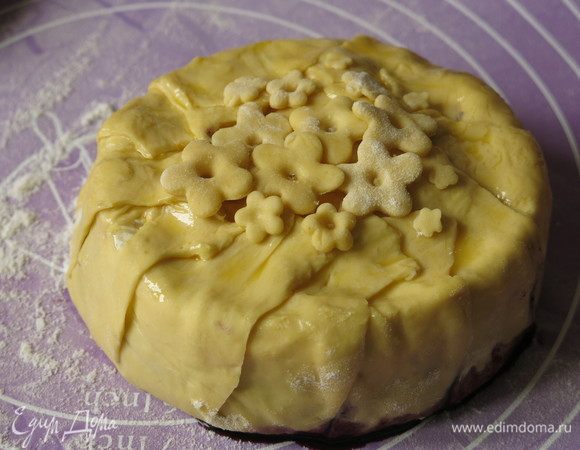 Из обрезков теста вырезаем цветочки. Смазываем все желтком с молоком.