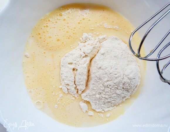 Влить постепенно 500 мл молока и 200 г муки, тщательно вымесить миксером на низкой скорости, чтобы не было комочков. В конце добавить 1 ст. л. оливкового масла и перемешать лопаткой.