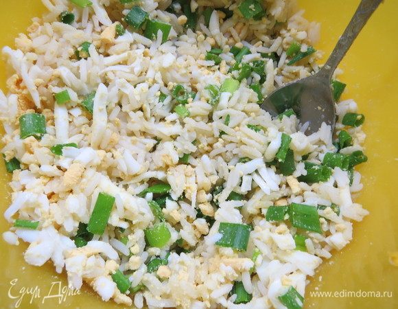 Перемешать рис и натертые яйца. Зеленый лук мелко нарезать, добавить к яйцам и рису, перемешать. Посолить и поперчить по вкусу. Начинка готова.